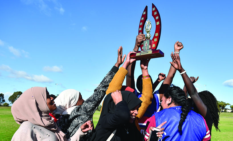 Girls holding Introduction to Mainstream Sports Program Gala Match Day trophy