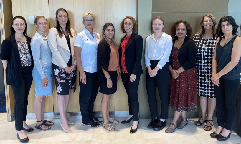 Members of the Victim Survivors' Advisory Council members stand in meeting place with Minister for Prevention of Family Violence Gabrielle Williams