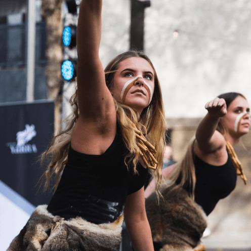 Two young women performing an Aboriginal dance 