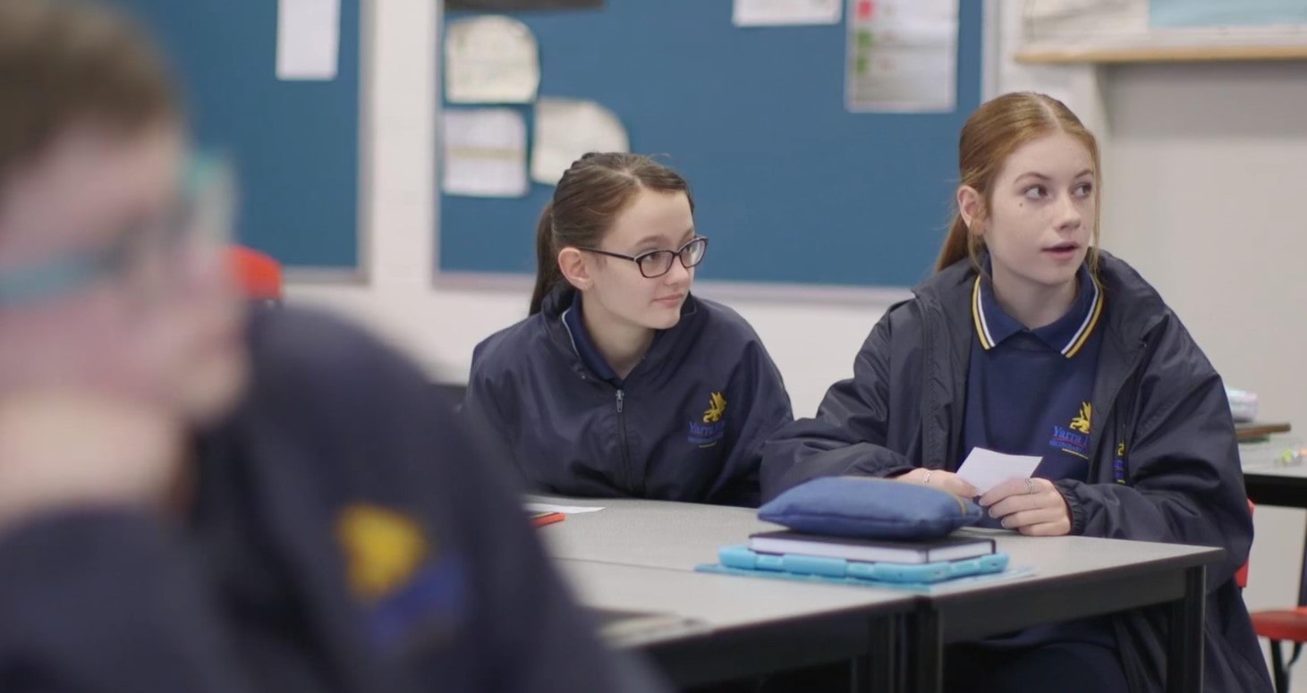 Two students sitting at a school desk.