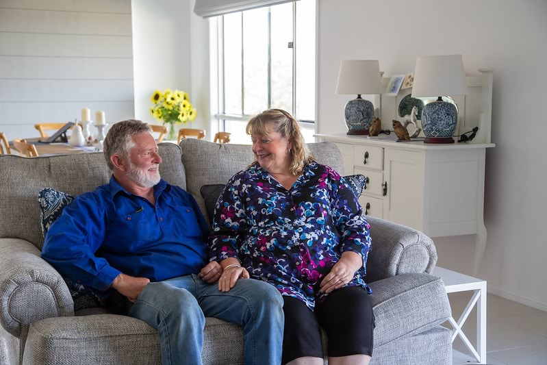 Kevin and Miulusa Giles sit on their couch in their home 