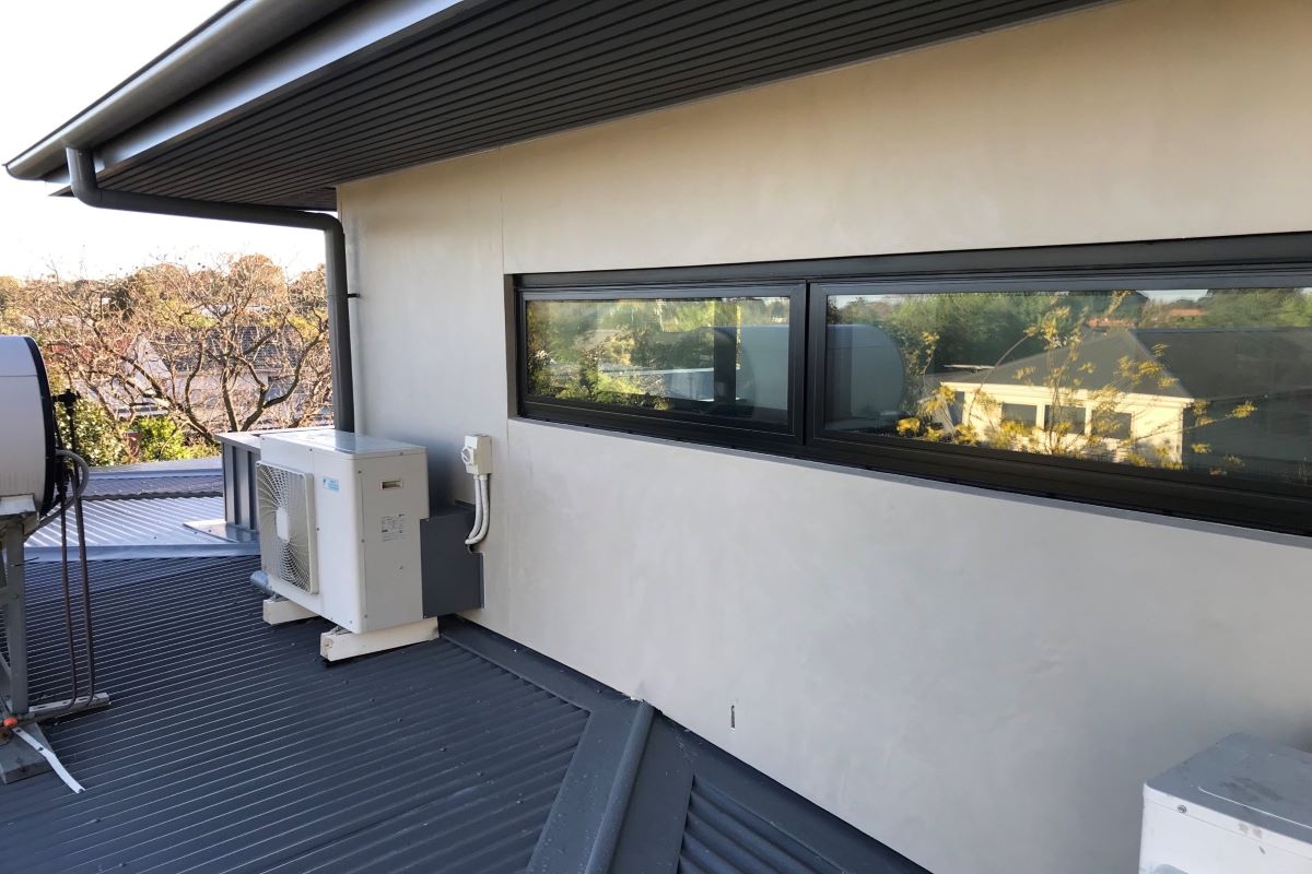 A building rooftop with window and air conditioning unit