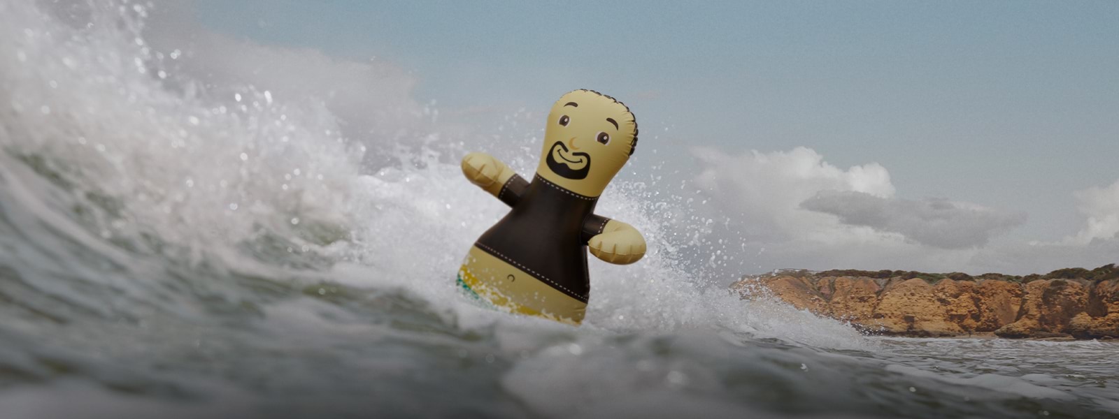 an inflatable man floating in the waves of a surf beach 