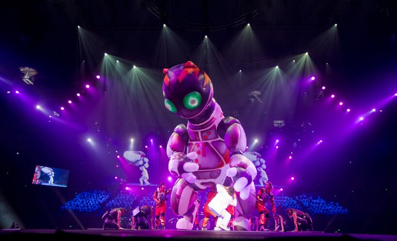 Giant robot cat puppet on the performance stage, surrounded by dancers