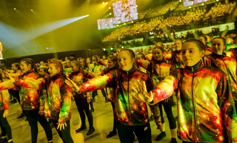 Massed dancers waving fans