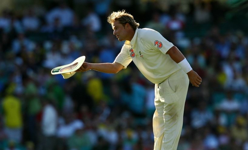 Mr Shane Warne tipping his hat on the cricket field.