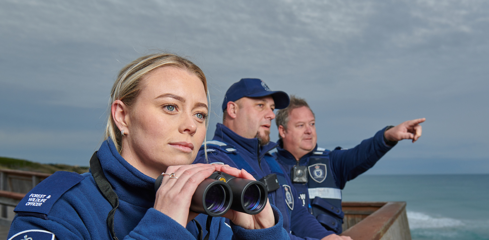 Image of forest and wildlife officers overlooking the ocean