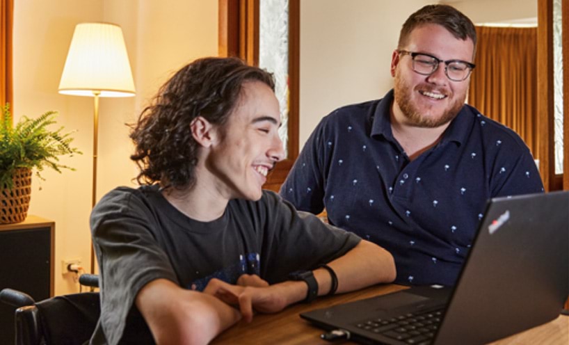 Carer helping client with laptop