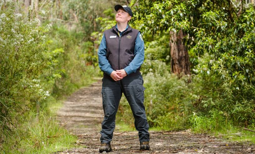 Bridget Grant standing on a path in bushland wearing a Parks Victoria Ranger uniform