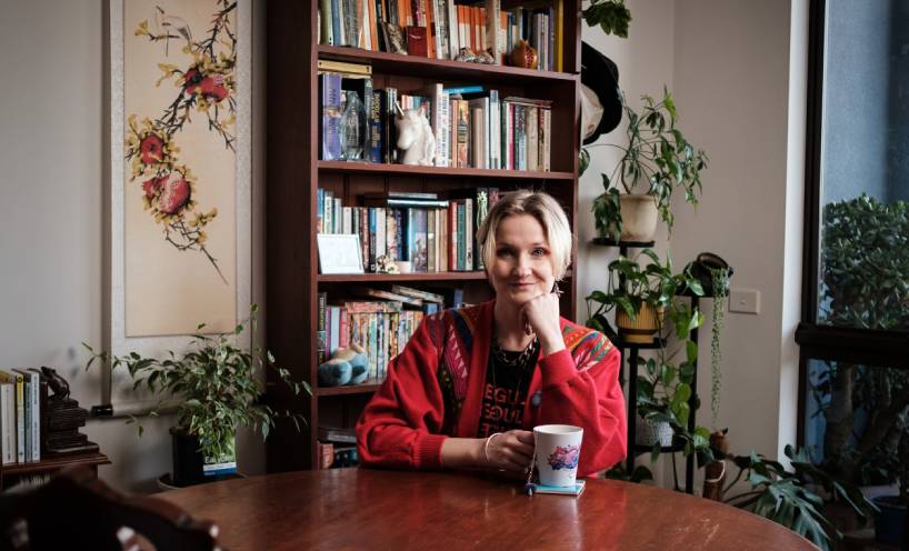 Ruby Mountford sitting at a table in front of a bookcase 