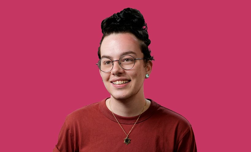 Image of graduate with pink background behind them