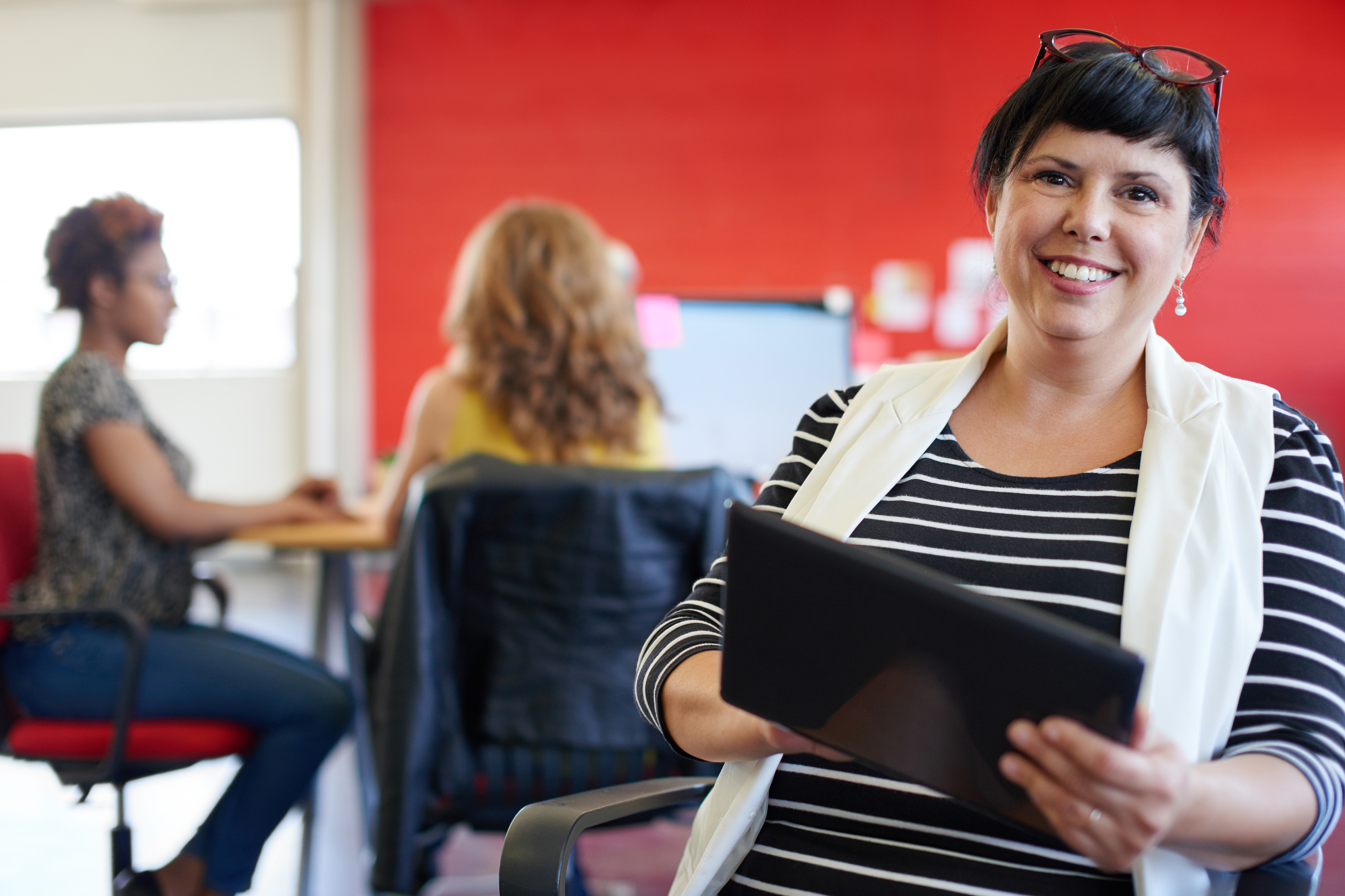 Business owner smiling to camera, holding an ipad