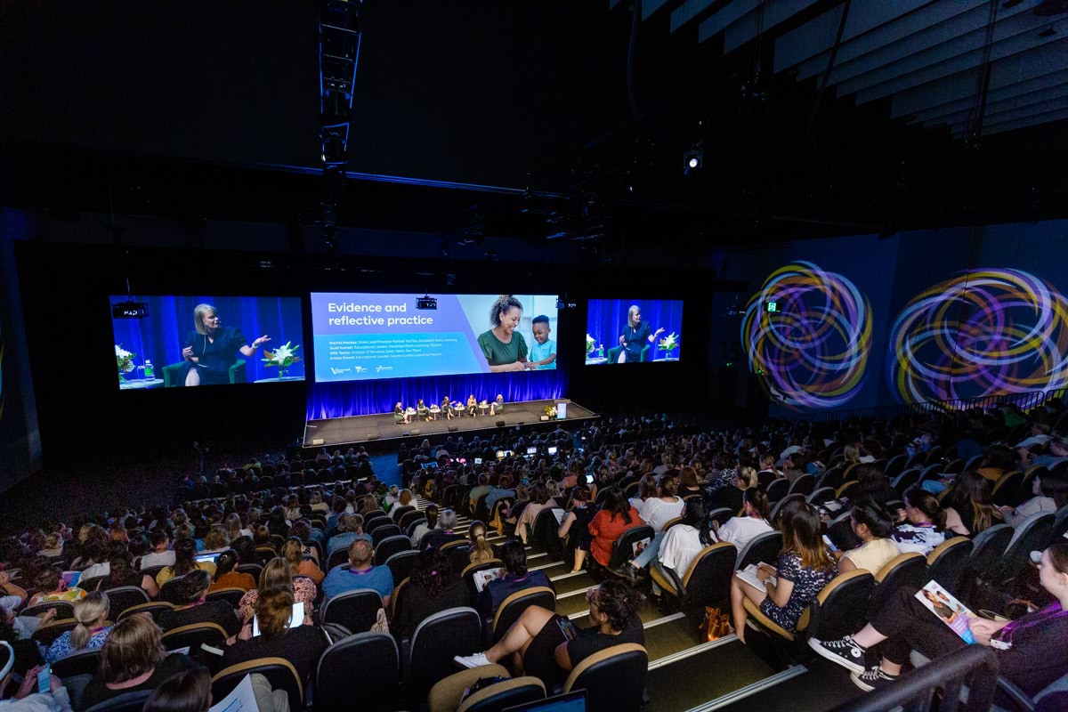 Large audience watching a panel discussion at the conference