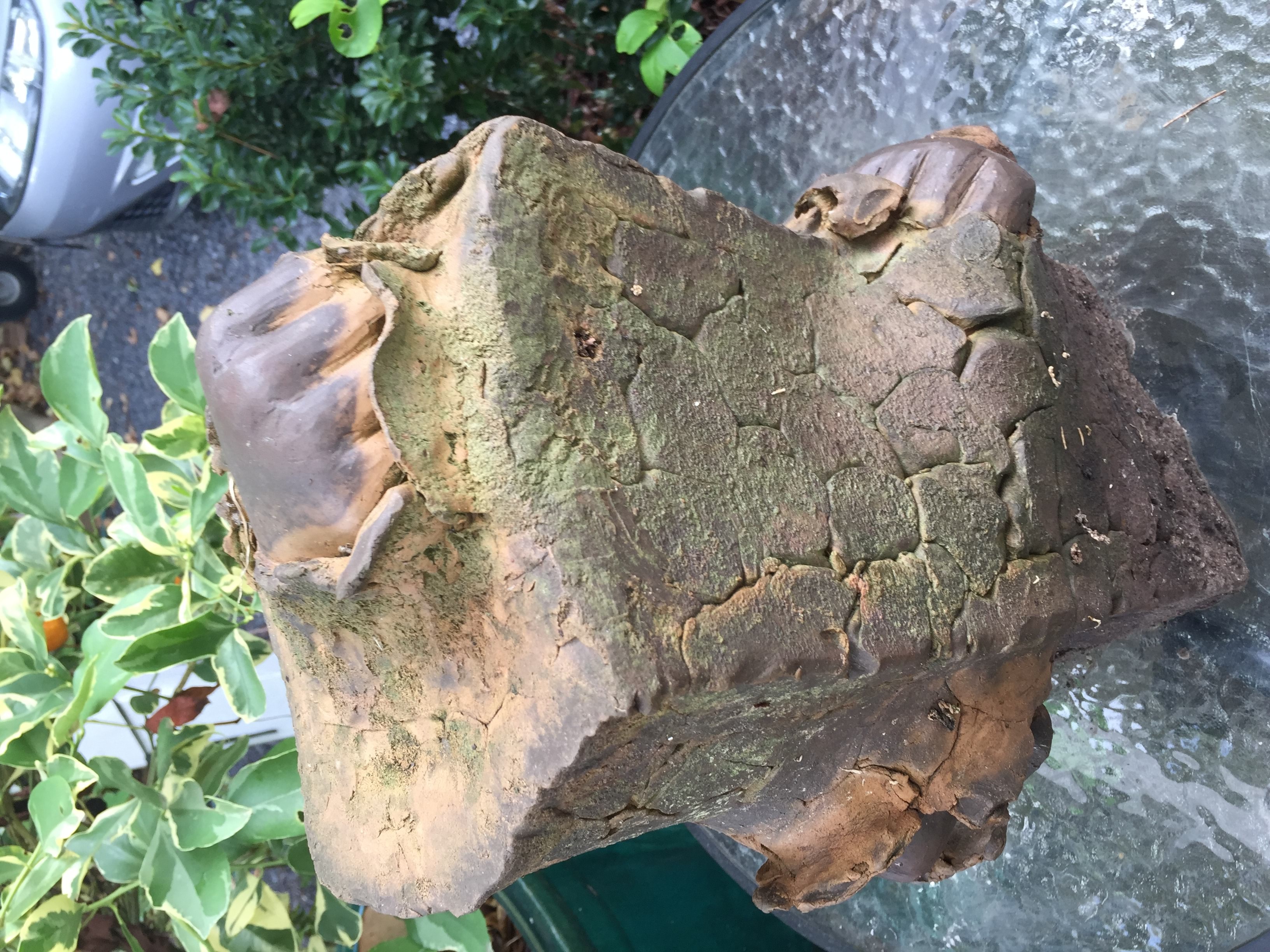 A pottery piece depicting a brick with three fists punching through the brick. 