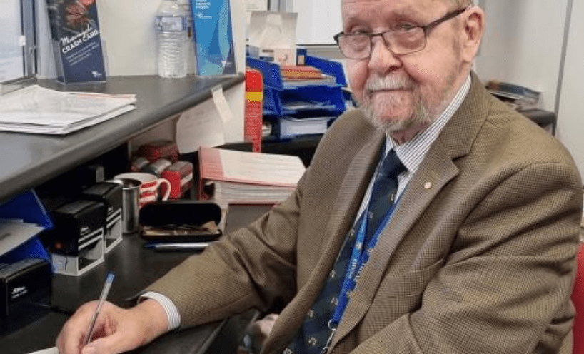 Bob Bolch posing at a desk at the Frankston Police Station DSS, where he has served for 17 years.