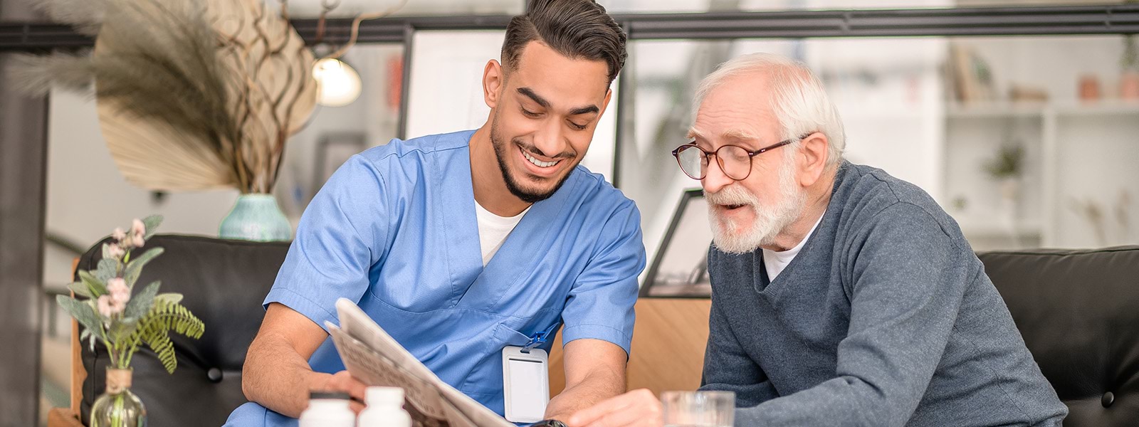 Aged carer reading newspaper with client