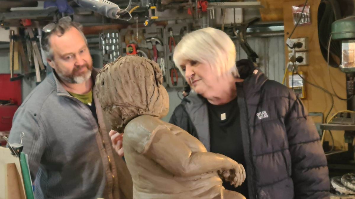 Sculptor Daniel Fraser and Lynne Young, Stella's Mum, touching up the hair on the clay sculpture of Stella.