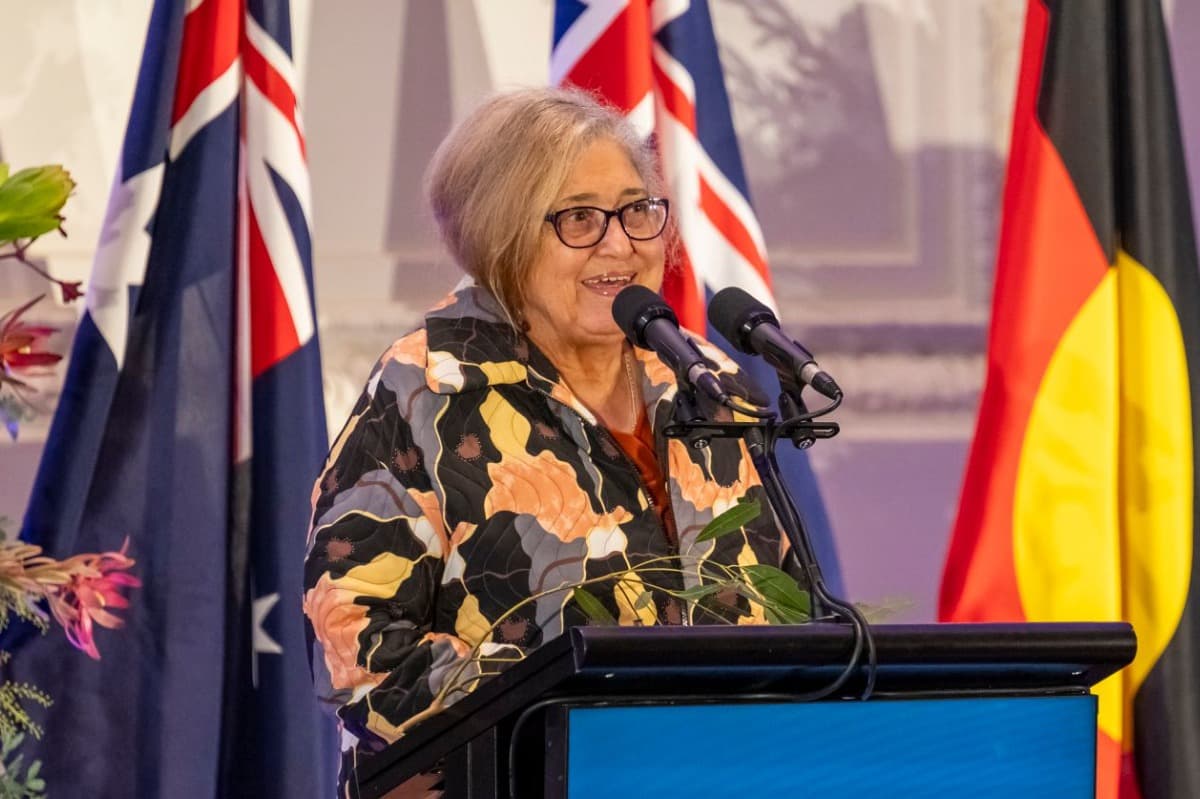 A woman speaking into microphone at podium