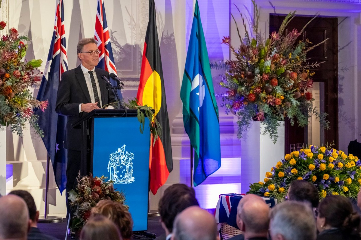 A man stands at a podium speaking into a microphone. 