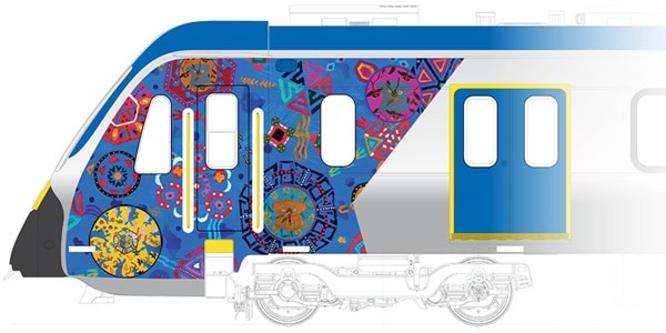 A blue and white train with artwork of various coloured circular artistic elements over a blue background 