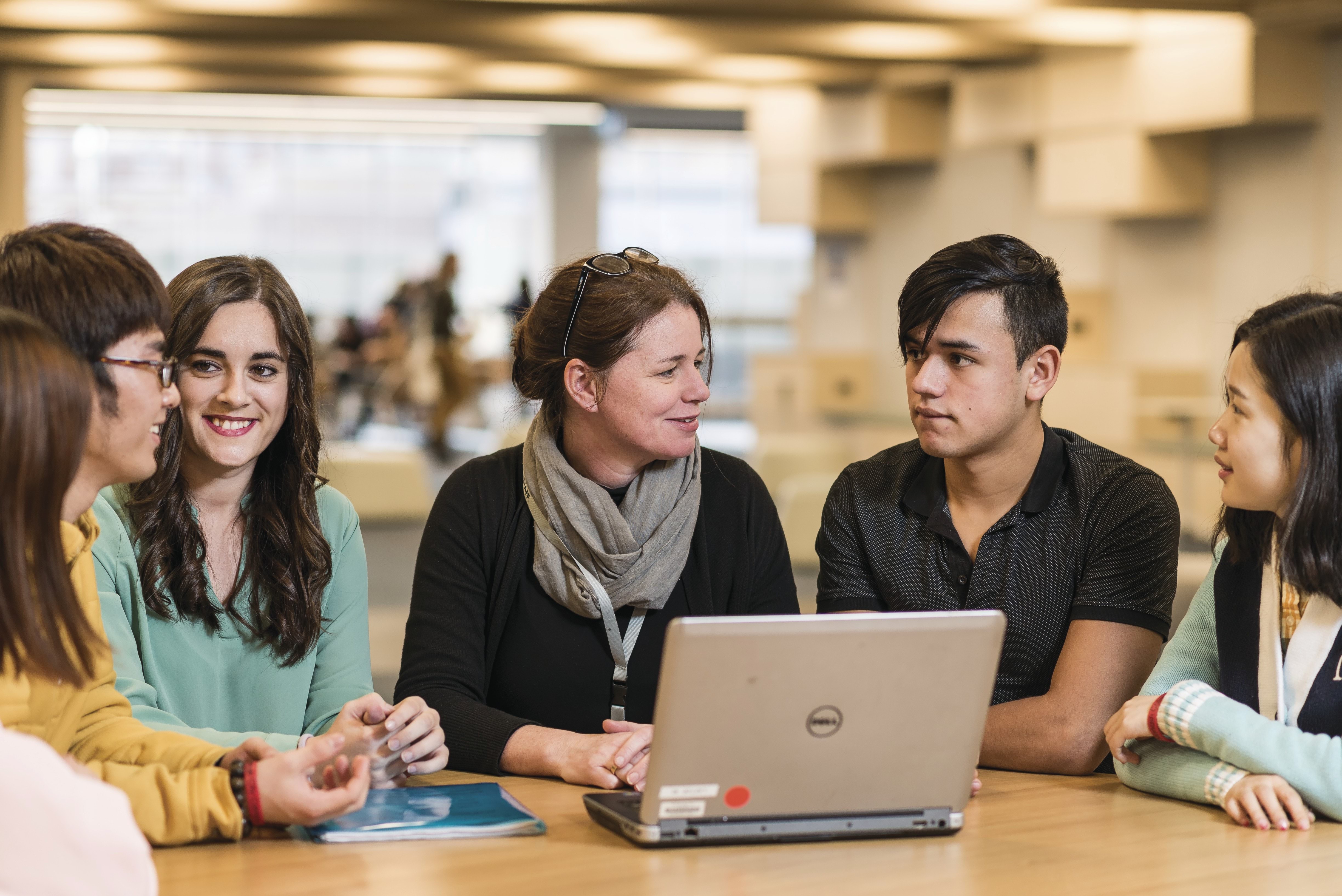 Group of students with tutor in library