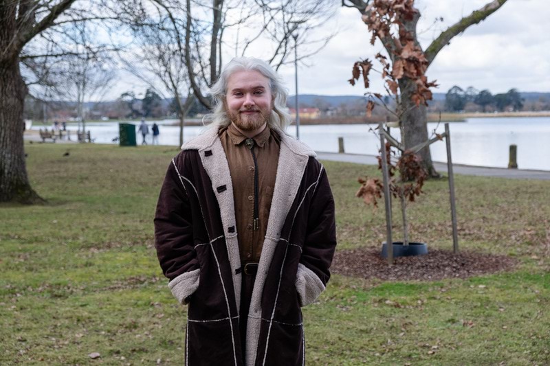 2023 Victorian Training Awards Koorie Student of the Year finalist Kurin Lelean standing outside near lake with his hands in his pockets and smiling at the camera