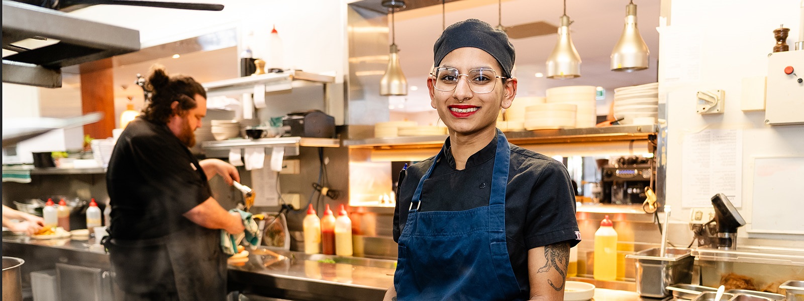 Leela 2023 Victorian Training Awards Apprentice of the Year cooking in a kitchen over a stove