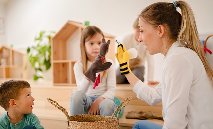 Decorative image of educator and children playing with puppets