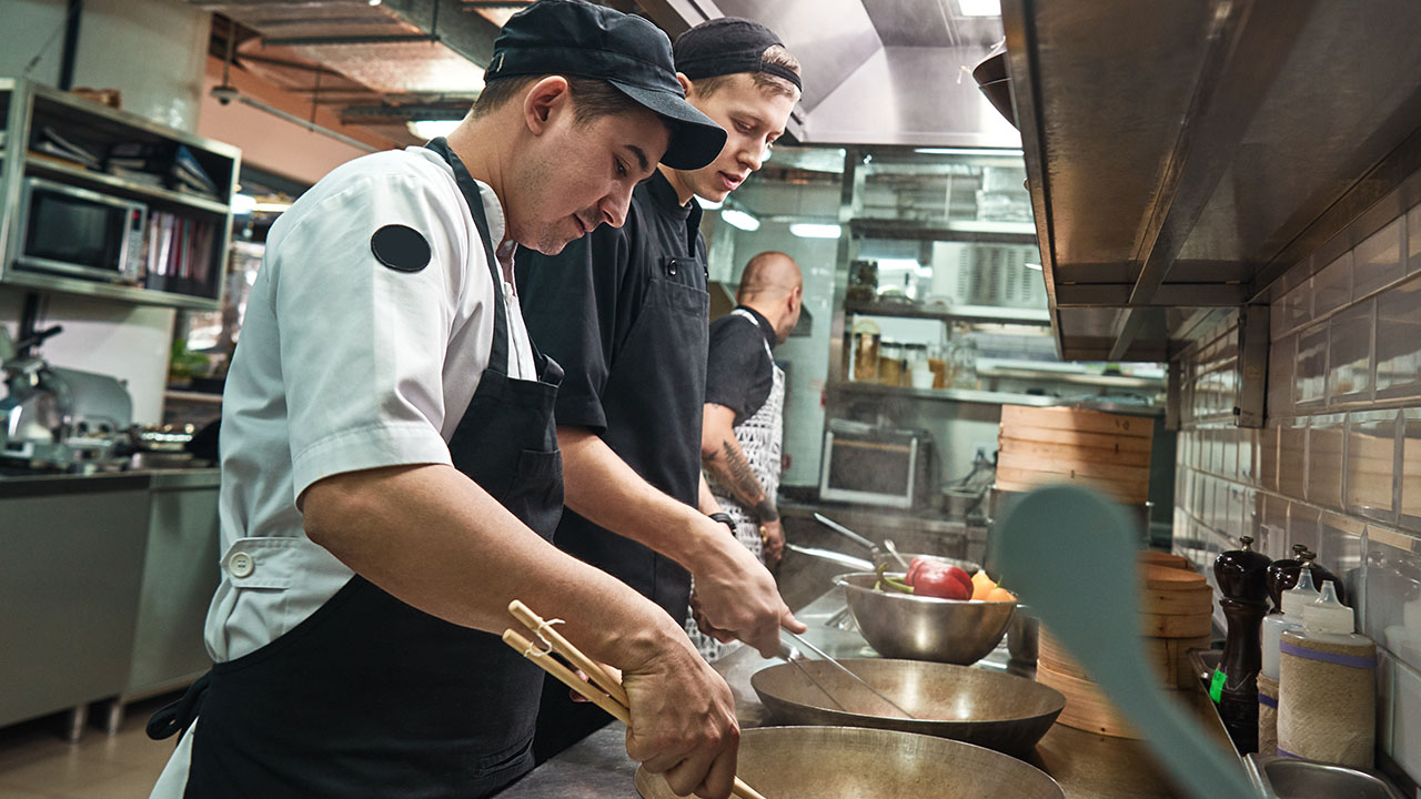 Two chefs cooking in commercial kitchen