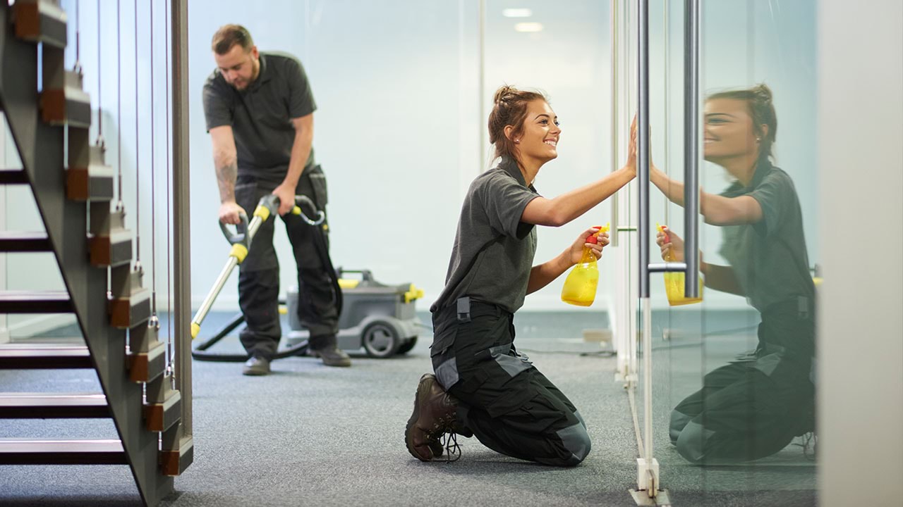 Two people cleaning office space