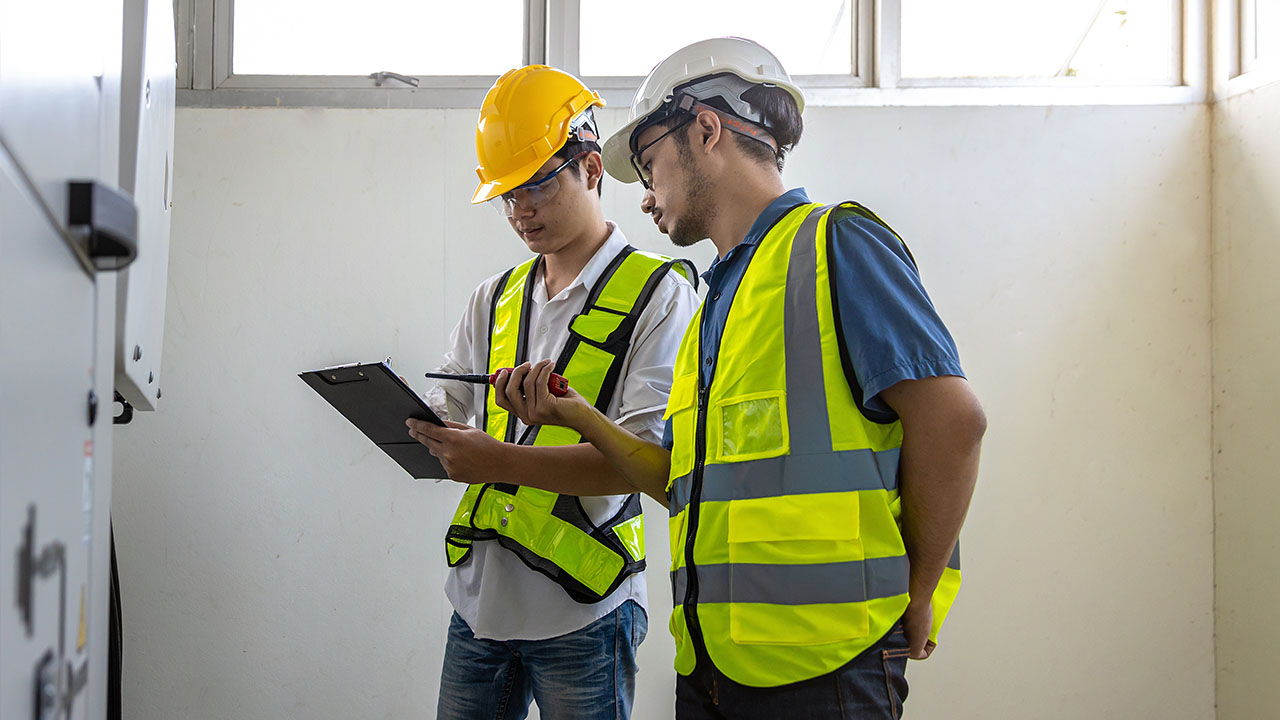 Two building inspectors talking with a clipboard