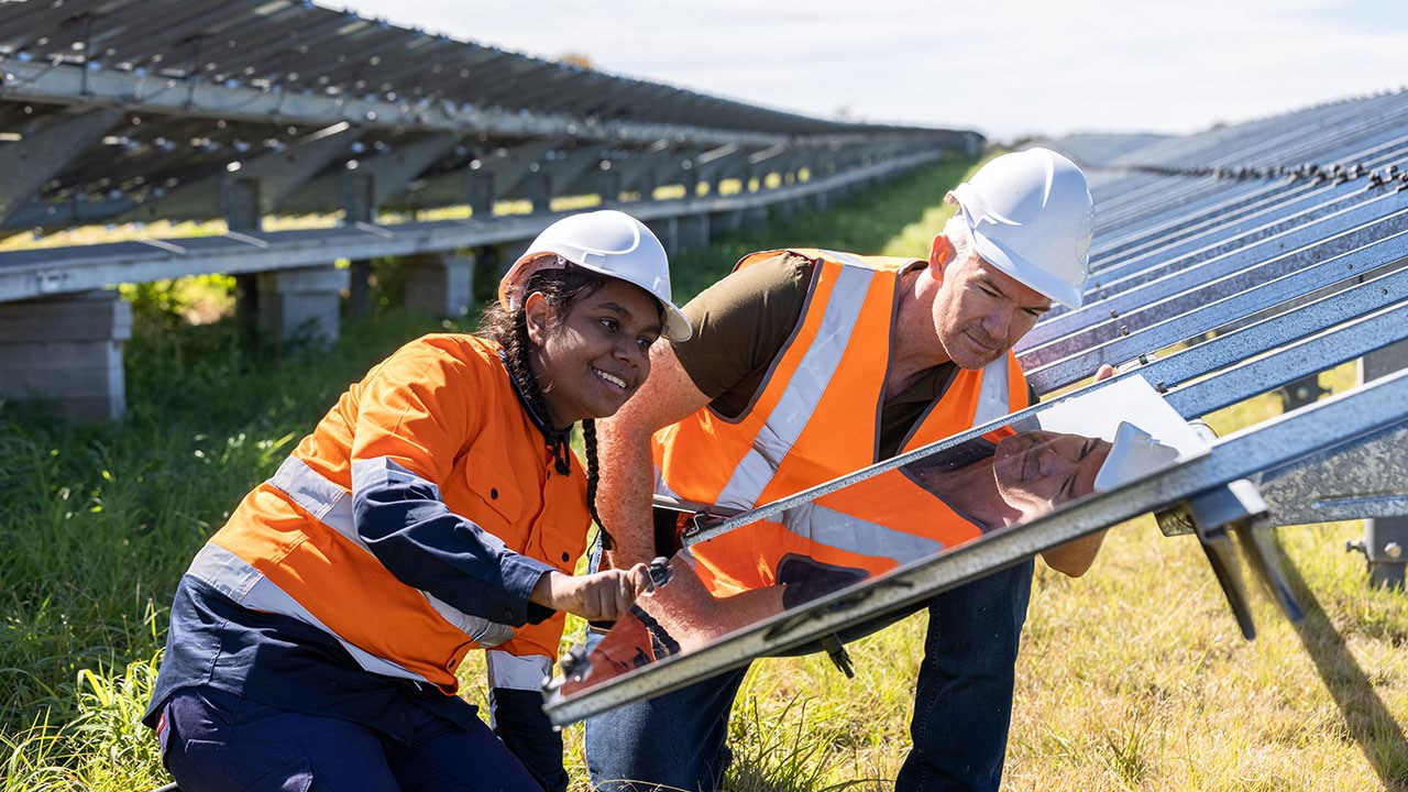 Two people working on solar panels