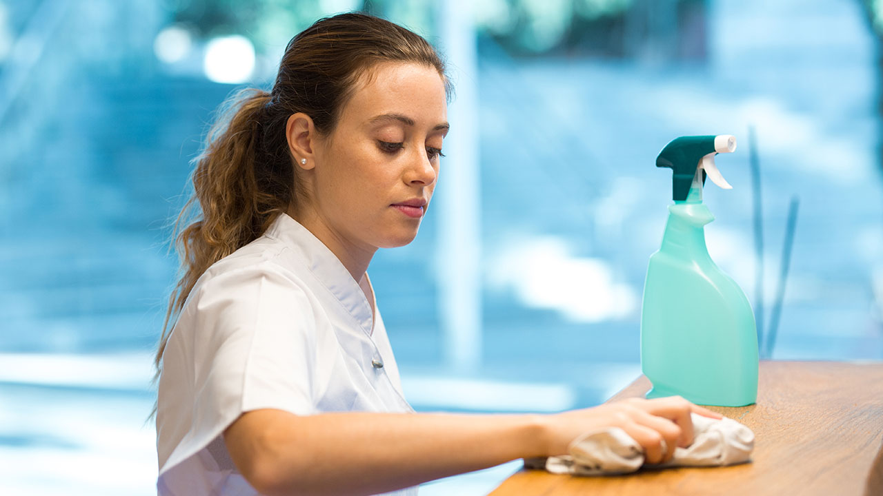 Person with cleaning product wiping a counter top 