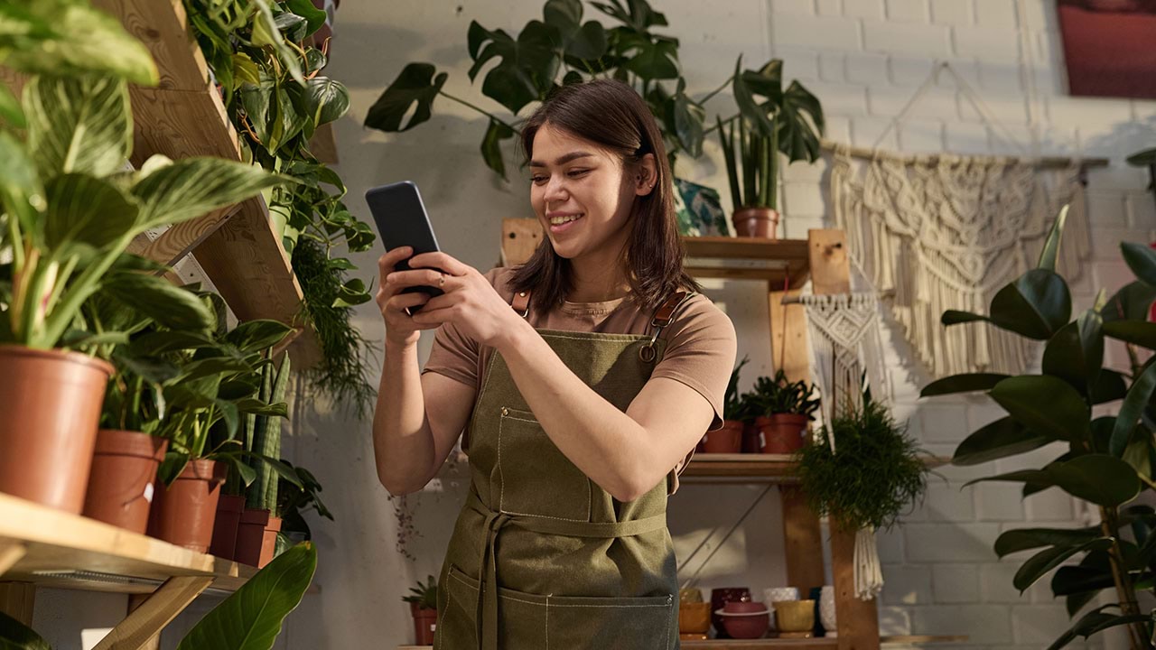 Person taking photo in retail setting with plants