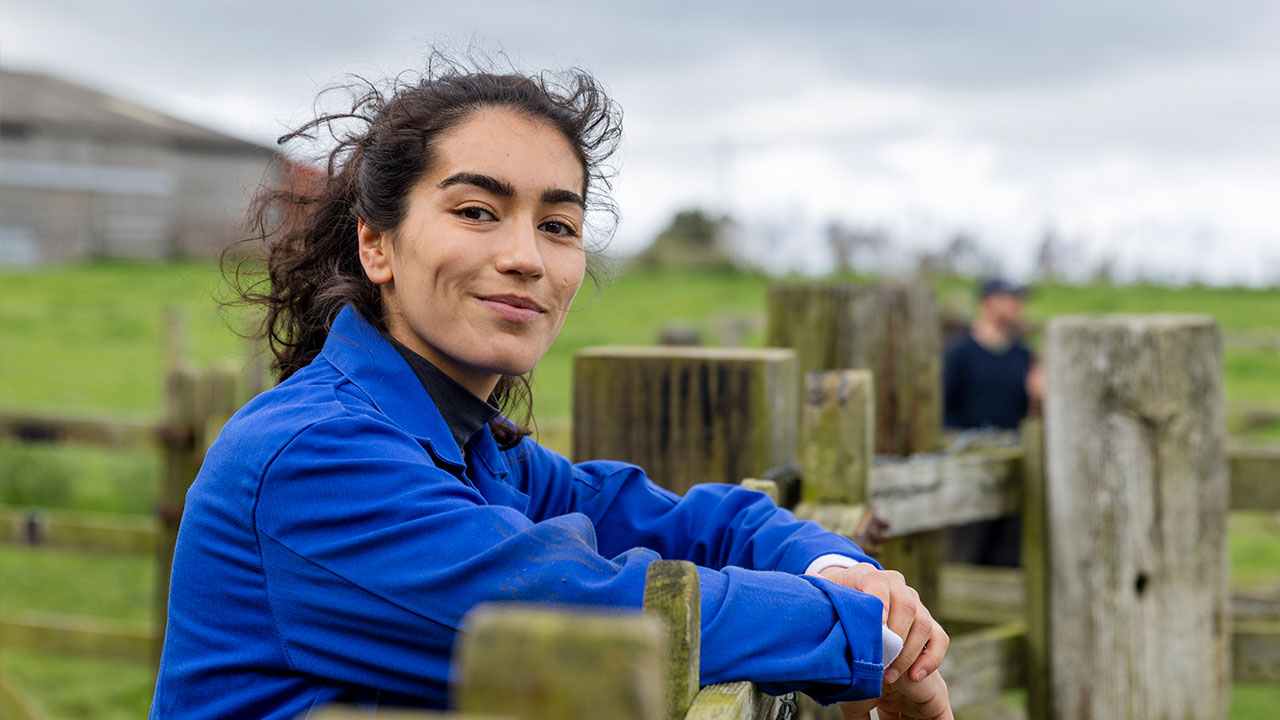 Farmer leaning on wooden fence