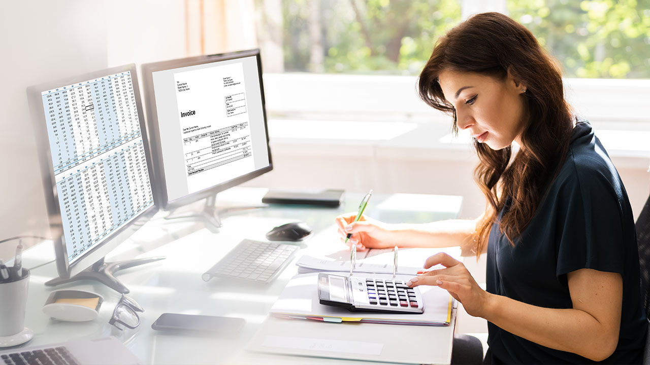 Person working at computer using a calculator