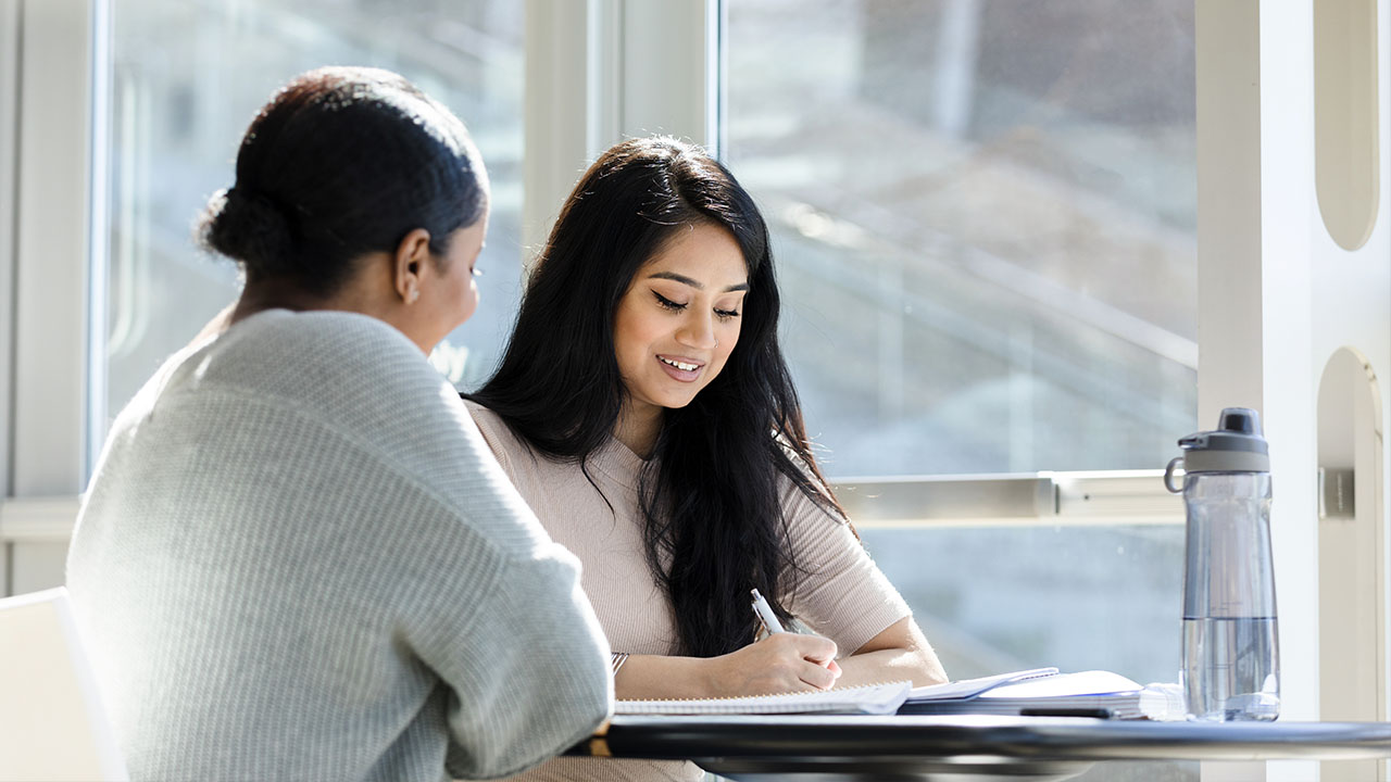 Two people looking at notes together