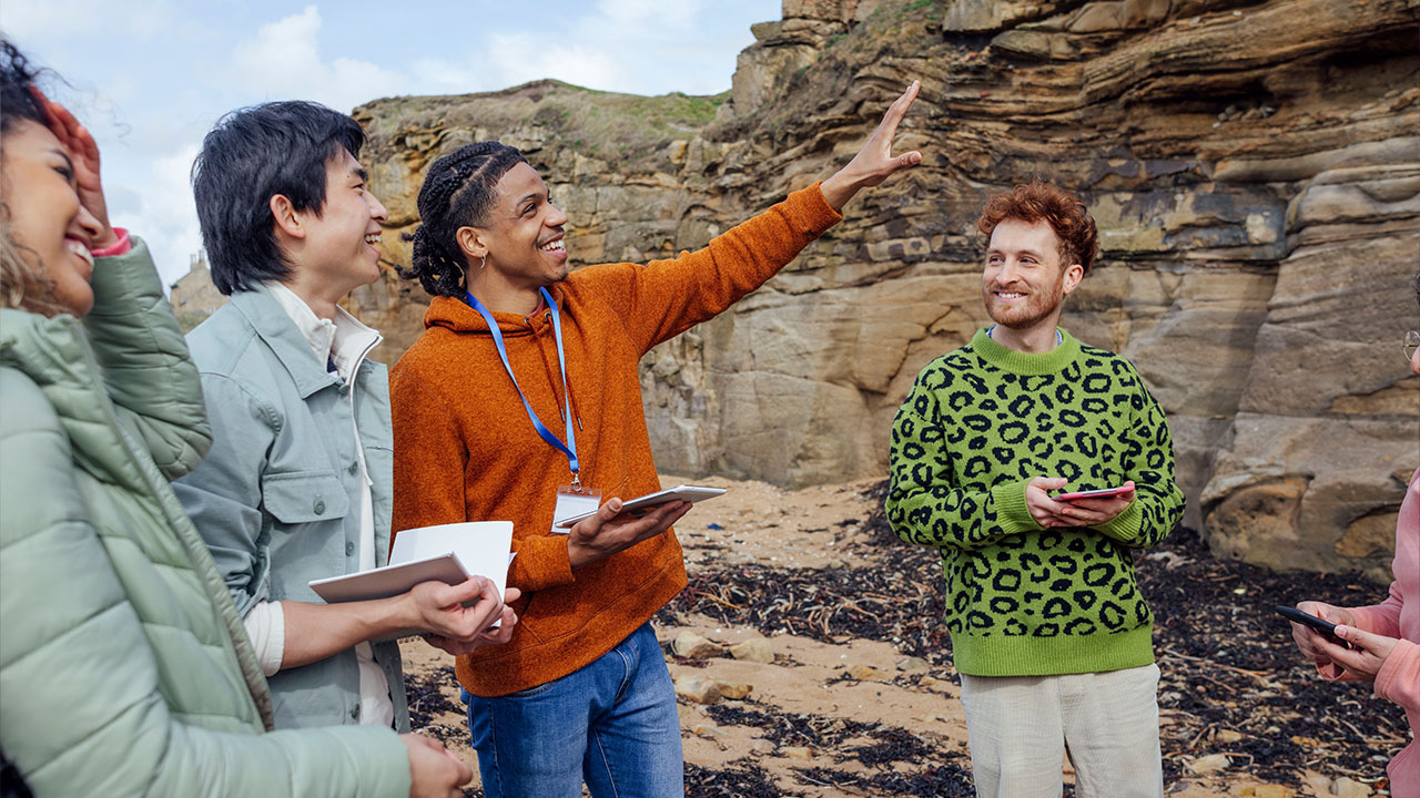 Outdoor adventure guide explaining rock formation with group of people