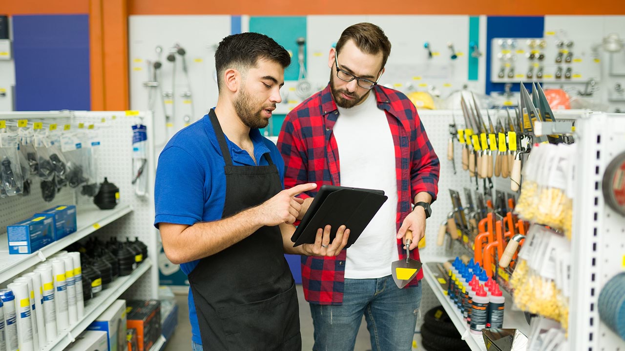 Two people in hardware store looking at handheld device