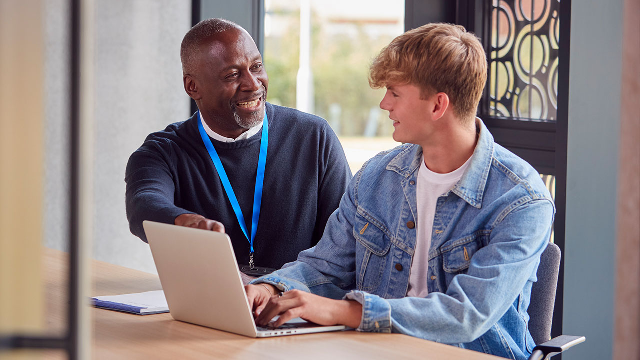 Two people looking into laptop together