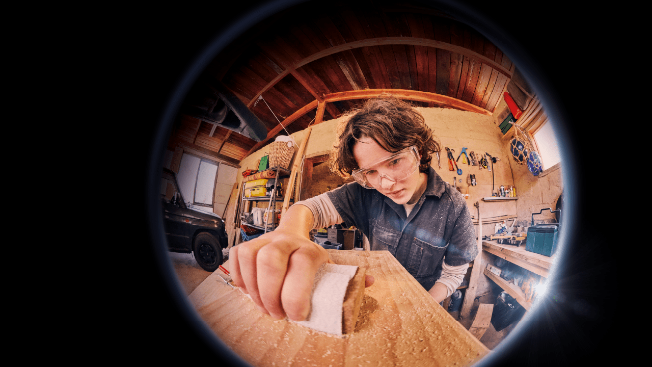 Teenage girl in overalls participating in woodworking 