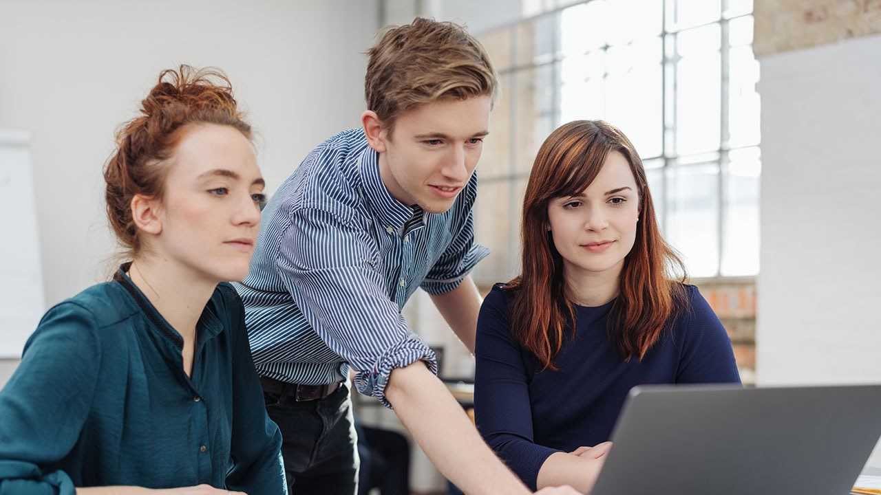 Group of people looking into laptop