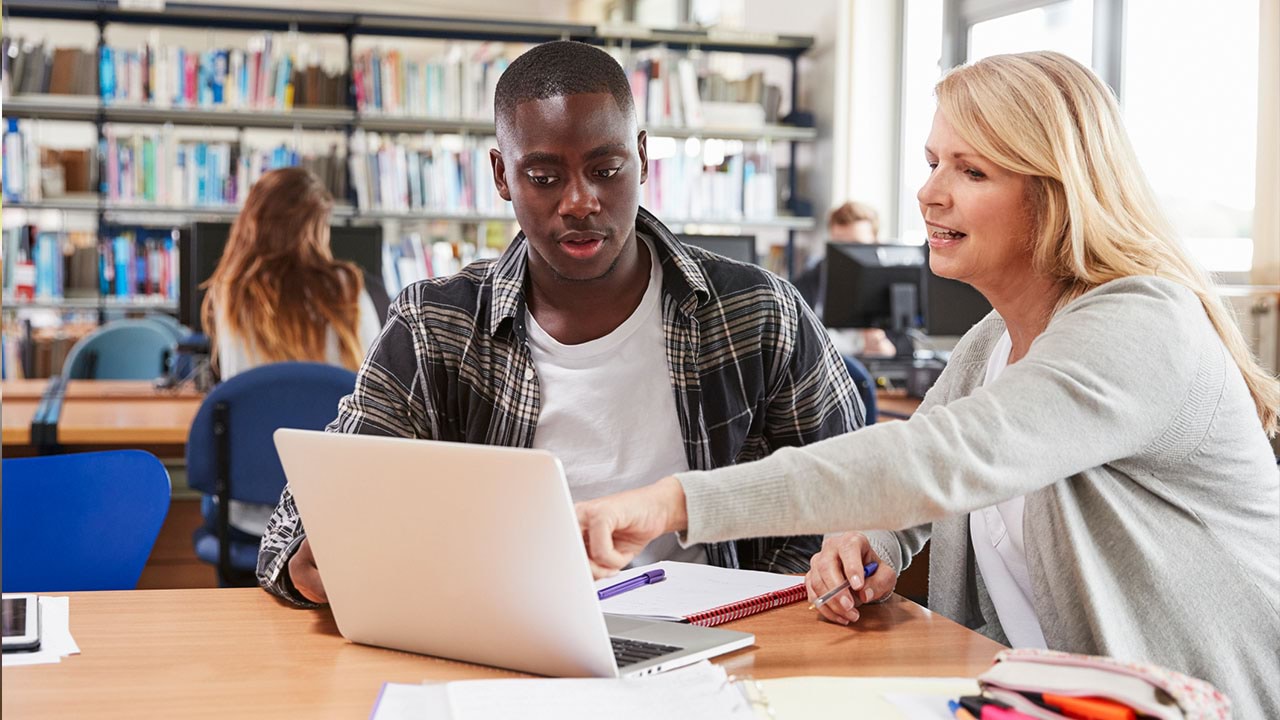 Two people looking into laptop together