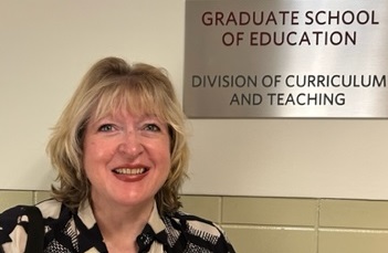 Happy person standing in front of conference signage