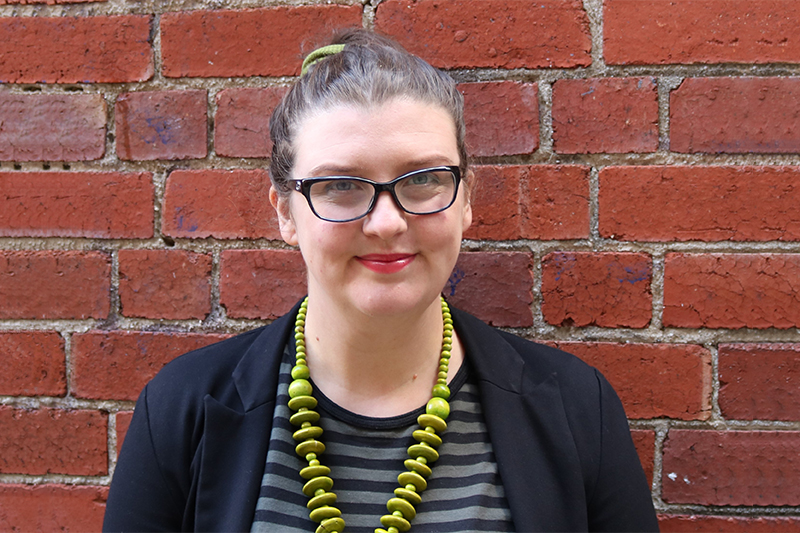 Research fellow in front of brick wall