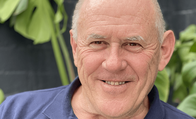 A close-up portrait of a man in a blue shirt