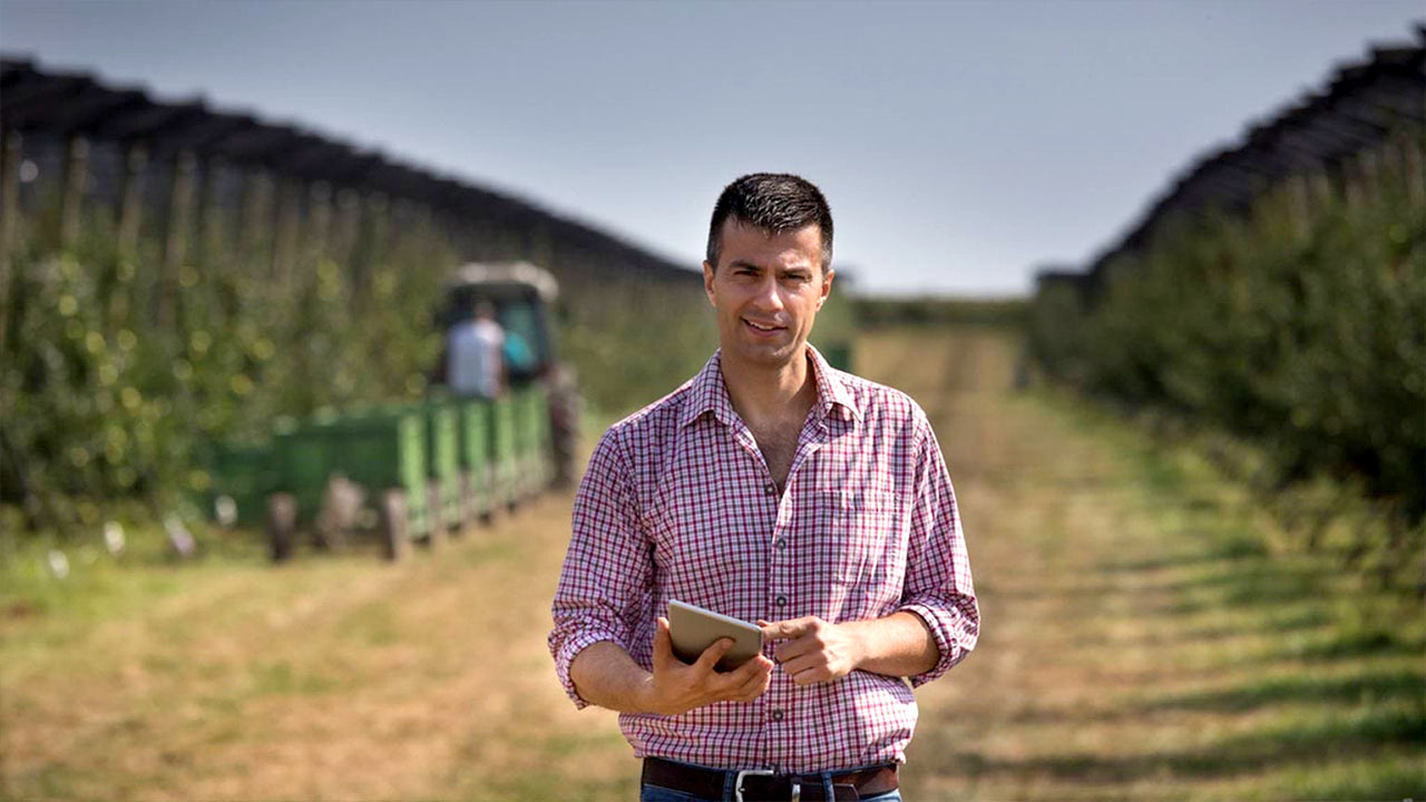 Person holding a device in agricultural setting