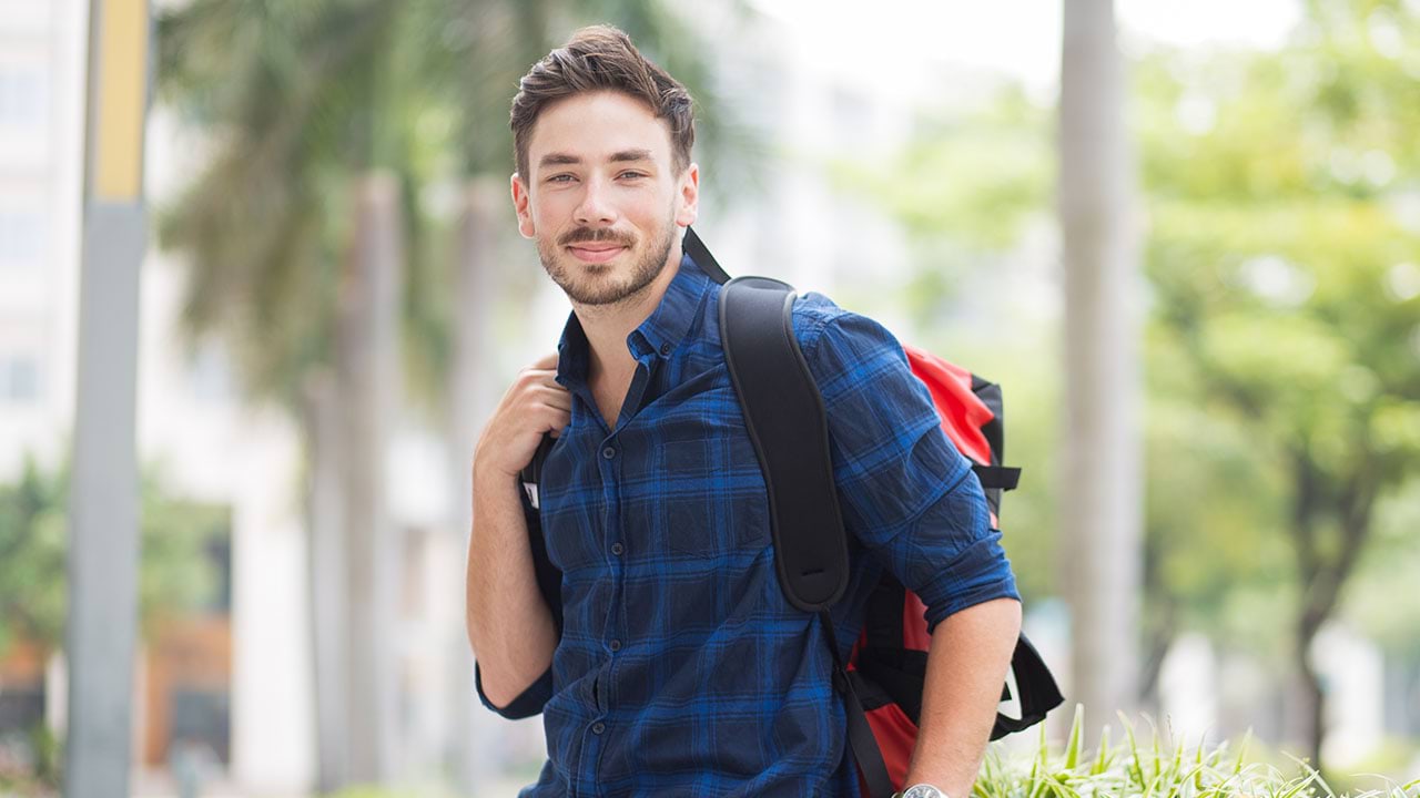 Person looking into the camera wearing a backpack