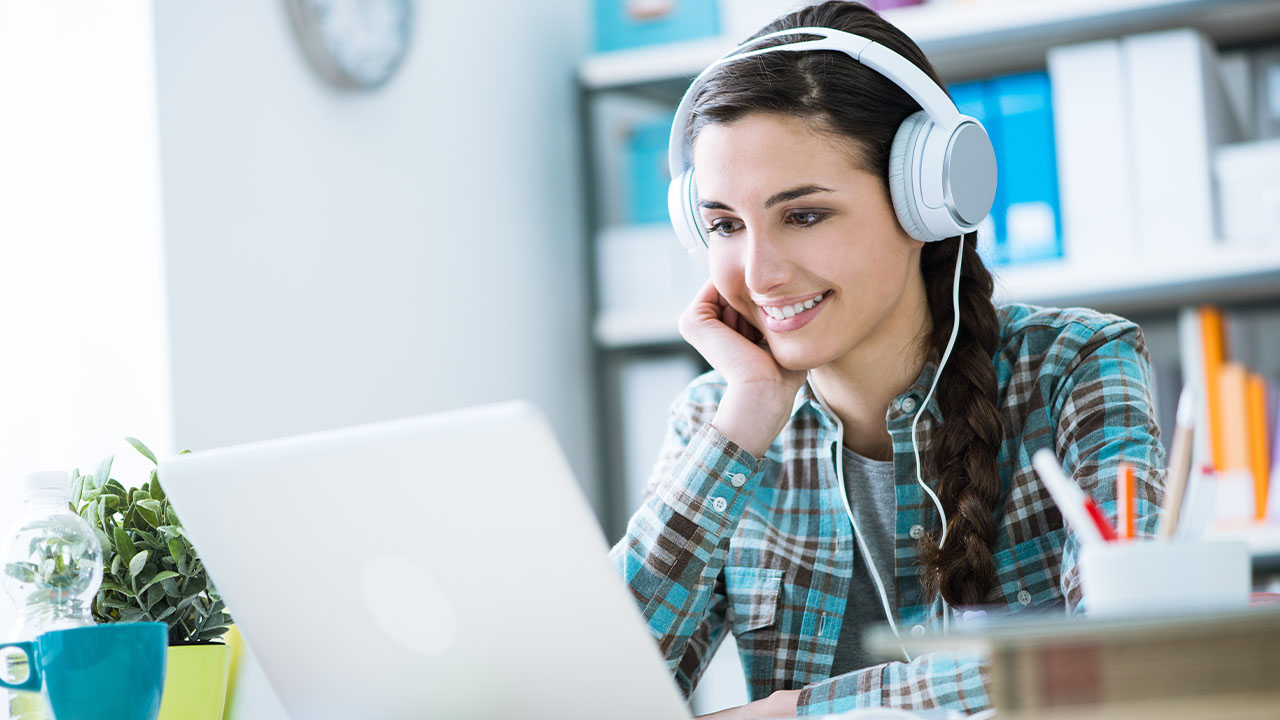 Student wear headphones using a laptop