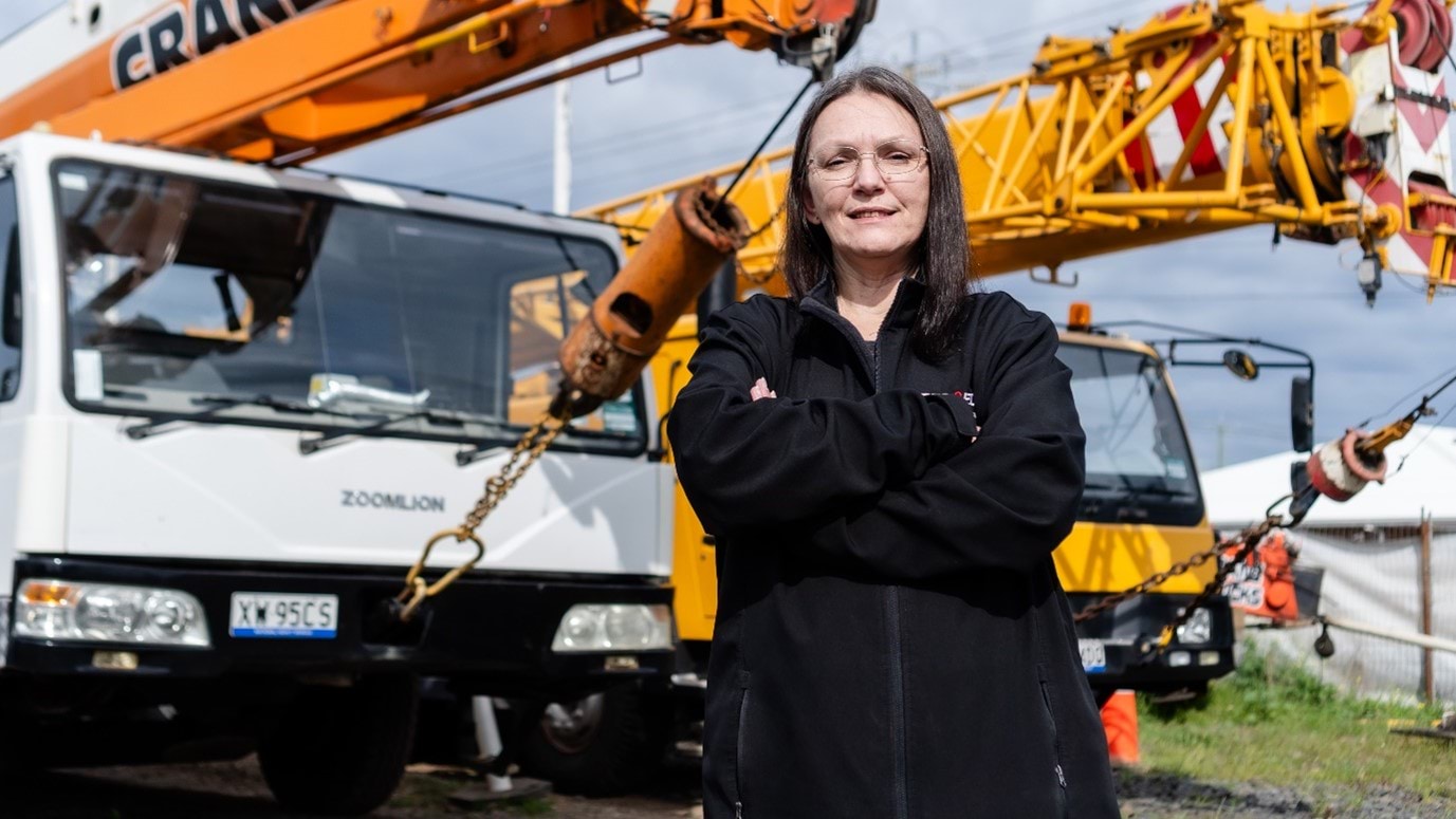 Amanda Gorman portrait, standing in front of two trucks with crane.